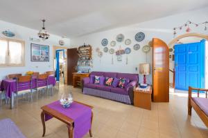 a living room with a purple couch and a table at Villa Lia Panorama in Pefki