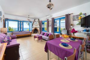 a living room with a purple table and chairs at Villa Lia Panorama in Pefki