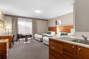 a hotel room with a bed and a kitchen at Quality Hotel Dickson in Canberra +35 photos