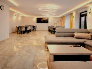 a living room with couches and a dining room at Hillcrest Panorama Valea Prahovei in Poiana Comarnic