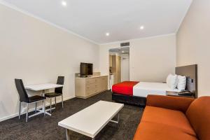 a hotel room with a bed and a couch and a table at Quality Hotel Manor in Mitcham +22 photos