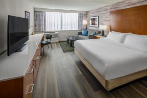 ein Hotelzimmer mit Bett und Fernseher in der Unterkunft DoubleTree by Hilton Rochester in Rochester