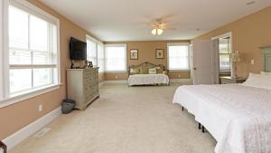 a bedroom with a bed and a tv and windows at 209 Congress Street in Cape May