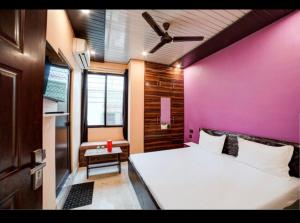 a bedroom with a large bed with a pink wall at Guest inn bharat mart in Haldwāni