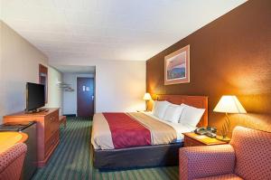 a hotel room with a bed and two chairs at Quality Inn Near Pimlico Racetrack in Baltimore