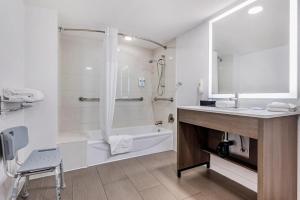 a bathroom with a tub and a sink and a shower at Comfort Inn Sea World Area in San Diego +29 photos