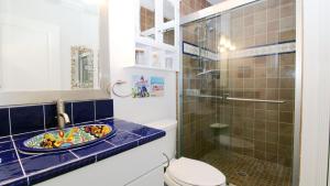 a bathroom with a toilet and a glass shower at The Roost Ii On Leaming in West Cape May +18 photos