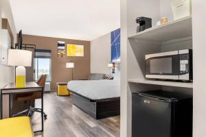 a hotel room with a bed and a microwave at Comfort Inn & Suites Springfield in Springfield