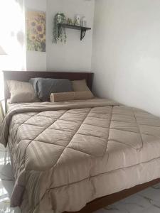 a large bed in a white room with a large blanket at Balay Buenavista in Magdalena