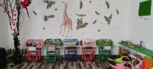 a classroom with tables and chairs and a giraffe on the wall at Pensiunea Terra Serenity in Snagov