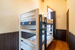 two bunk beds in a room with a bed at Goodfellas Onsen House in Niseko