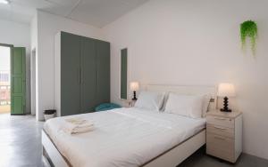a white bedroom with a large bed with white sheets at Aceh Suites by Aayu - 1 min walk to Armenian St in George Town +30 photos