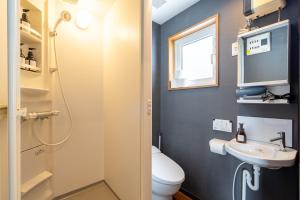 a bathroom with a toilet and a sink at Goodfellas Onsen House in Niseko +18 photos