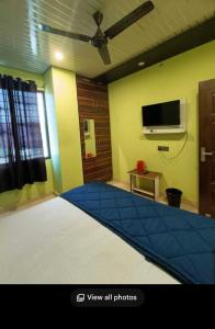 a living room with a tv and a blue carpet at Guest inn bharat mart in Haldwāni