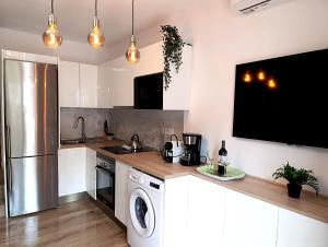 a kitchen with a dishwasher and a tv on the wall at Zen House in Maspalomas