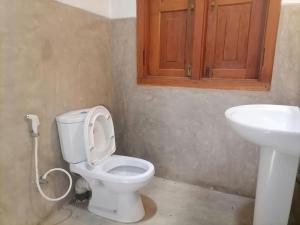 a bathroom with a toilet and a sink at Swastha Retreat in Polgahawila