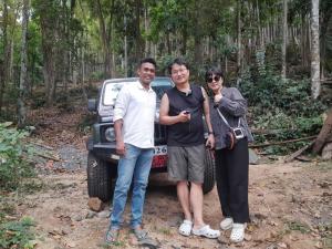 two men and a woman standing in front of a car at Swastha Retreat in Polgahawila