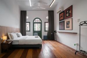 a bedroom with a large bed and wooden floors at Aceh Suites by Aayu - 1 min walk to Armenian St in George Town