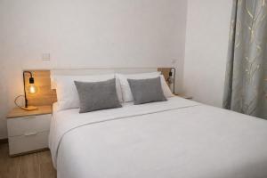 a bedroom with a large white bed with two pillows at Zen House in Maspalomas
