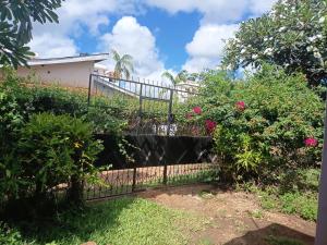 a gate in the yard of a house with roses at Honeymoon villa Diani in Diani Beach