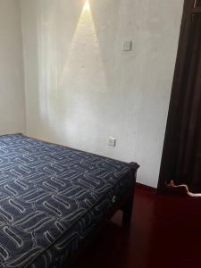a bedroom with a bed in a room with a wall at Maria Ceylon Villa in Tangalle