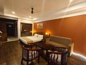 a room with a bed and a couch and a table at HOTEL SKY PARADISE in Iritti