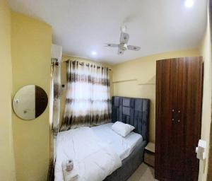 a small bedroom with a bed and a ceiling fan at E&V APARTMENT Berger Express in Iseri-Oke