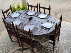 a wooden table with plates and dishes on it at Villa Mountain Pearl in Chikmagalūr