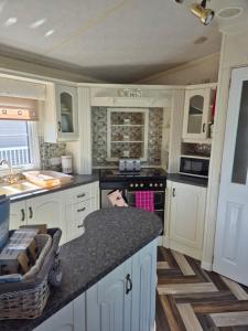 a kitchen with white cabinets and a counter top at Caravan 6 berth in Ingoldmells