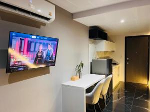 a living room with a television on a wall at Stylish Condo Near Nai Harn Beach Full Facilities Utopia M720 in Rawai Beach