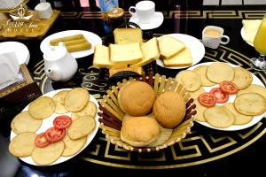 a table topped with plates of food and cheese at Cuzzy Inn Stay in Lahore