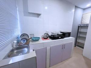 a small kitchen with a sink and a stove at E&V APARTMENT Berger Express in Iseri-Oke