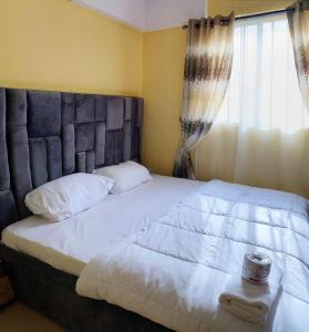 a bedroom with a large white bed with a window at E&V APARTMENT Berger Express in Iseri-Oke