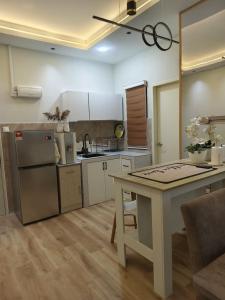 a kitchen with a table and a counter top at MyShelter Melaka in Kelebang Besar