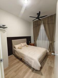 a bedroom with a bed with a ceiling fan at MyShelter Melaka in Kelebang Besar