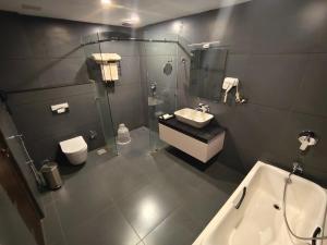 a bathroom with a sink and a shower and a toilet at HOTEL SKY PARADISE in Iritti +24 photos