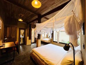 a bedroom with a bed and a desk and a window at Nabum Retreat in Làng Giang +21 photos