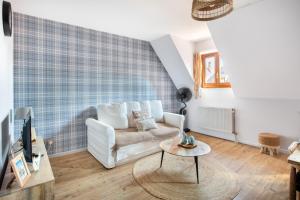 a living room with a white couch and a table at Le P'tit Bretzel in Turckheim