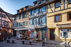 a street with a store in the middle of buildings at Le P'tit Bretzel in Turckheim