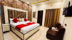 a bedroom with a large bed with red pillows at New Like Home Hotel in Lahore