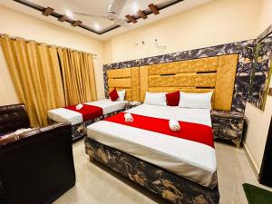 two beds in a room with red and white at New Like Home Hotel in Lahore +19 photos