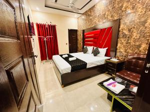 a bedroom with a bed with a red head board at New Like Home Hotel in Lahore