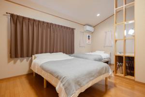 a hospital room with two beds and a window at Nagoya Homestay in Nagoya