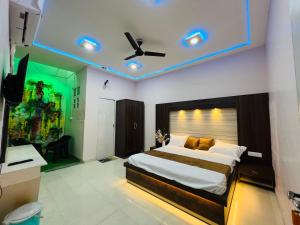 a bedroom with a large bed with a ceiling fan at Hotel green garden in Ludhiana