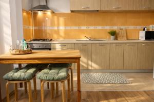 a kitchen with a wooden table with stools in it at RNR Airport 3 in Otopeni