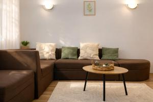a living room with a brown couch and a table at RNR Airport 3 in Otopeni