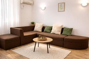 a living room with a brown couch and a table at RNR Airport 3 in Otopeni +1 photo