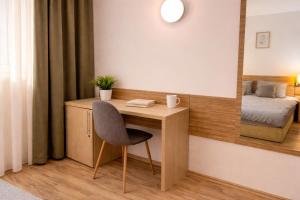 a room with a desk with a chair and a mirror at RNR Airport 3 in Otopeni