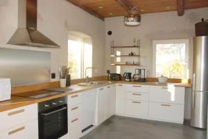 a kitchen with white cabinets and a stove at Drängagården in Klagstorp +31 photos