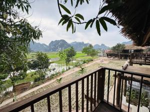 a balcony with a view of a field and mountains at Nabum Retreat in Làng Giang